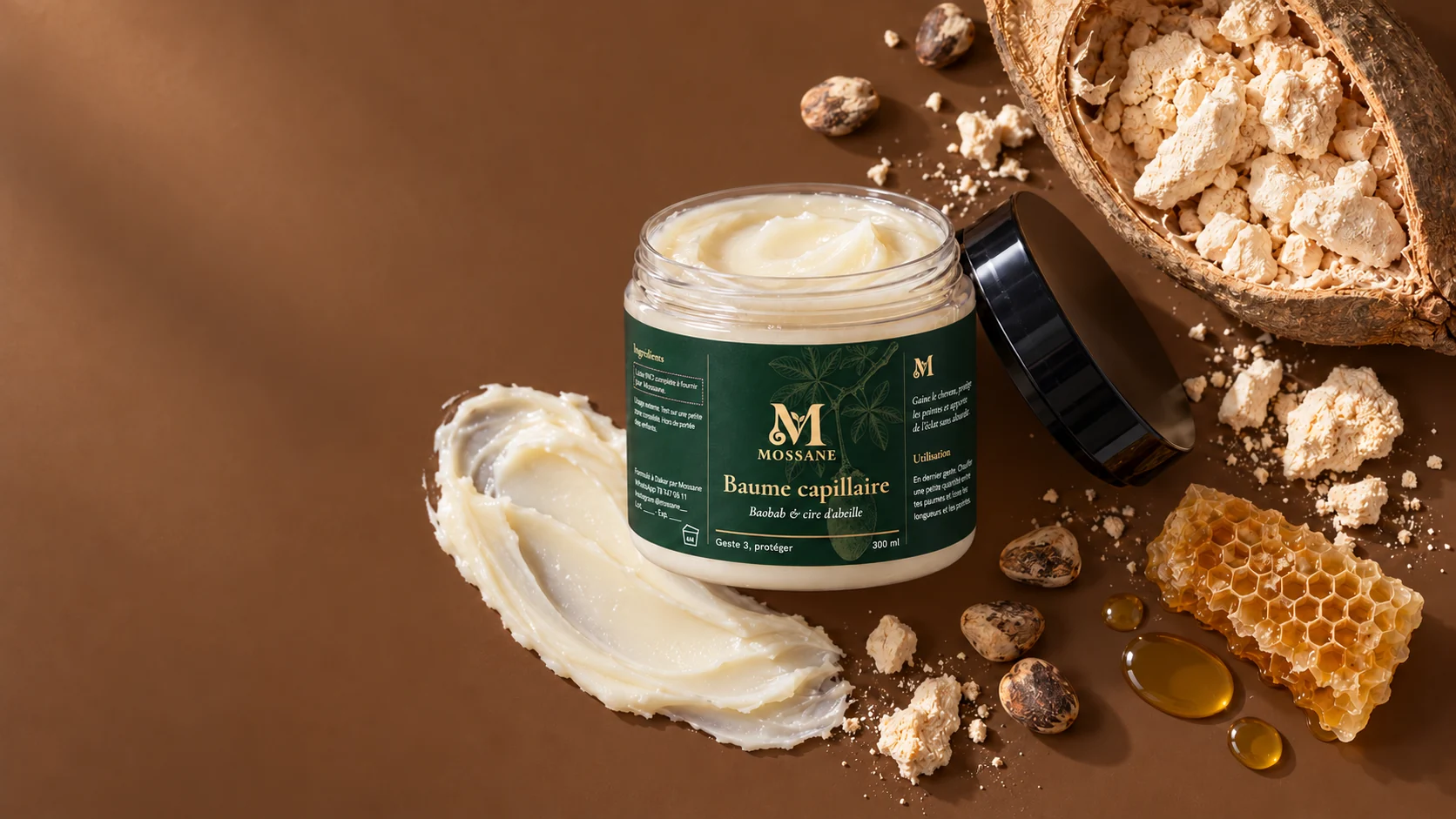 Le pot de baume Mossane ouvert, une trace de baume, un fruit de baobab ouvert, ses graines et un rayon de miel
